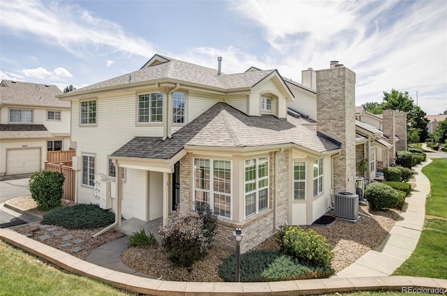 2040 S Xenia Way, Denver, CO 80231 - view of front of home with a shingled roof, brick siding, and a chimney