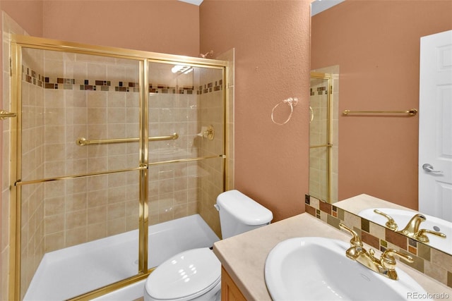 bathroom with vanity, toilet, and a shower with shower door