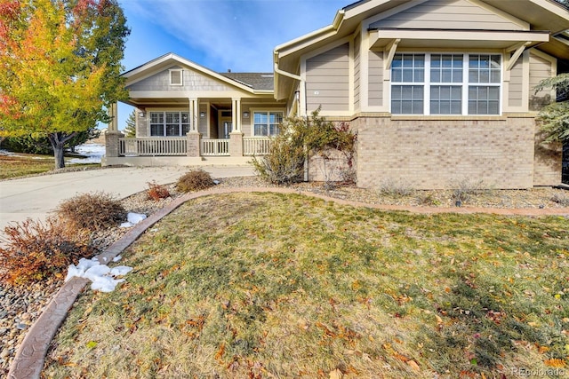 view of front of home with a porch and a front yard