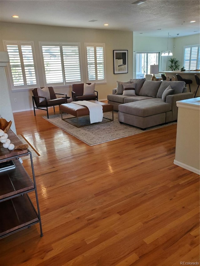 living room with a textured ceiling and light hardwood / wood-style flooring