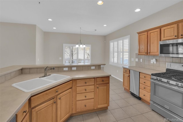 kitchen featuring sink, tasteful backsplash, an inviting chandelier, hanging light fixtures, and stainless steel appliances