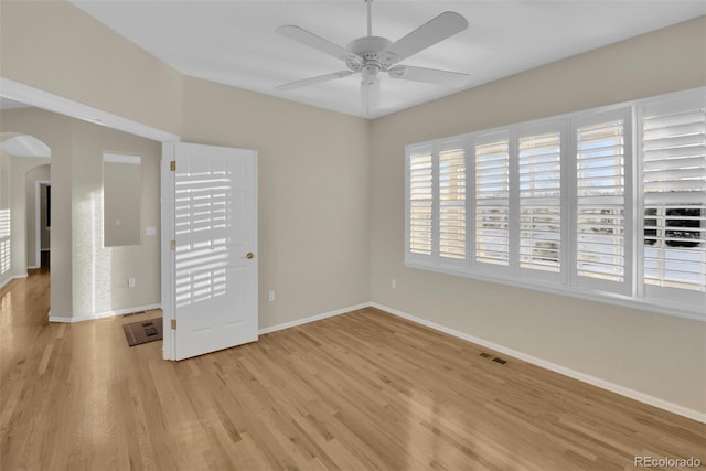 empty room with ceiling fan and light hardwood / wood-style flooring