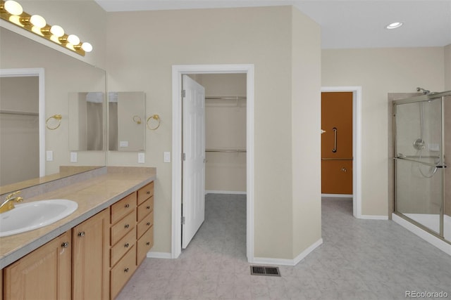 bathroom featuring vanity and a shower with shower door