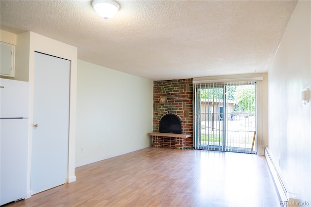 1302 S Parker Rd Unit 134, Denver, CO 80231 - unfurnished living room with a textured ceiling, light wood-style flooring, a fireplace, and a baseboard radiator
