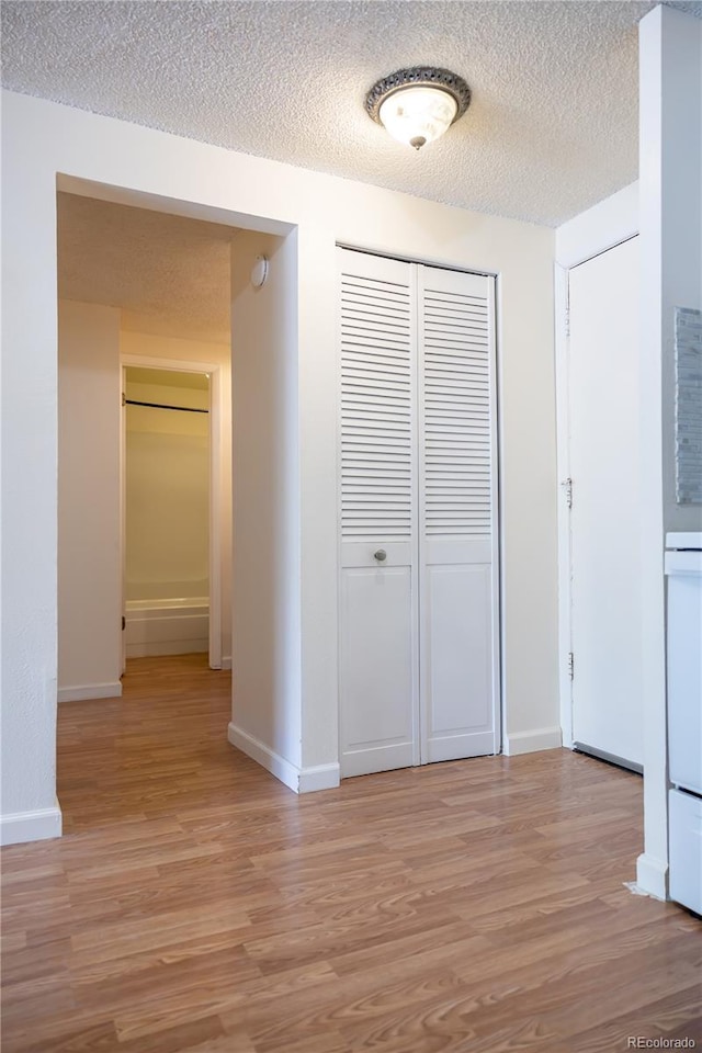 1302 S Parker Rd Unit 134, Denver, CO 80231 - hallway with light wood-style floors and a textured ceiling
