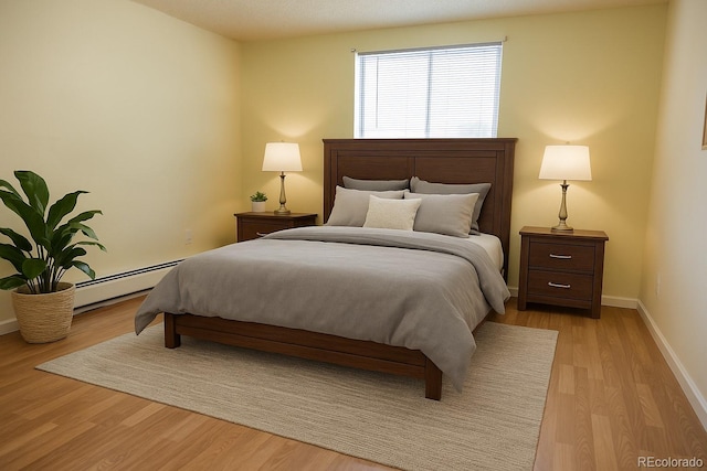 1302 S Parker Rd Unit 134, Denver, CO 80231 - bedroom with a baseboard heating unit and light wood-type flooring