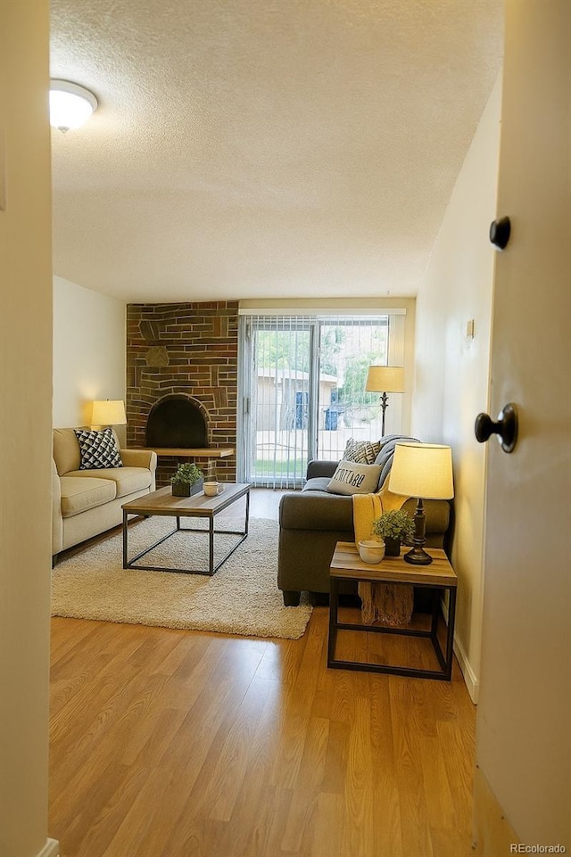 1302 S Parker Rd Unit 134, Denver, CO 80231 - living room with wood finished floors, a textured ceiling, and a stone fireplace