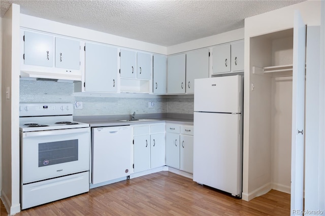 1302 S Parker Rd Unit 134, Denver, CO 80231 - kitchen with white appliances, custom exhaust hood, decorative backsplash, light wood finished floors, and a textured ceiling