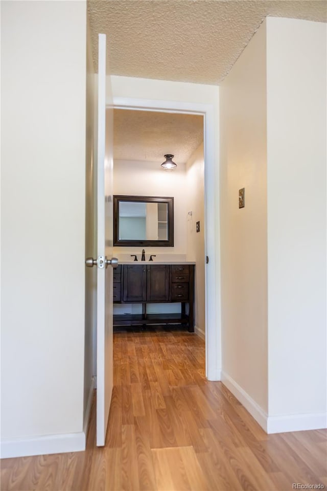 1302 S Parker Rd Unit 134, Denver, CO 80231 - corridor with a textured ceiling and light wood-style flooring