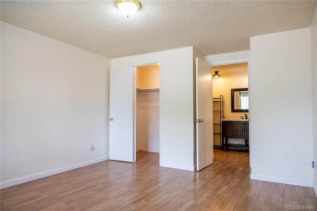 1302 S Parker Rd Unit 134, Denver, CO 80231 - unfurnished bedroom with wood finished floors, a textured ceiling, a closet, and a spacious closet