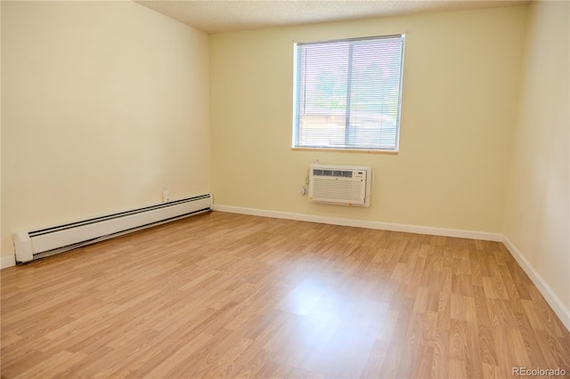 1302 S Parker Rd Unit 134, Denver, CO 80231 - unfurnished room with a baseboard heating unit, a wall unit AC, and light wood-type flooring