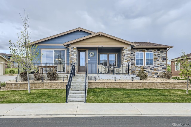 view of front facade with covered porch and stone siding