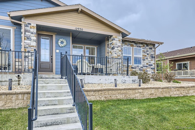 view of front of home with a porch and stone siding