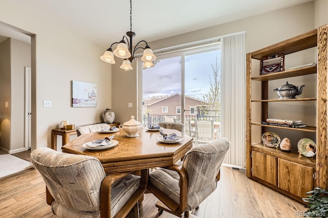 dining area featuring an inviting chandelier, visible vents, and light wood-style floors