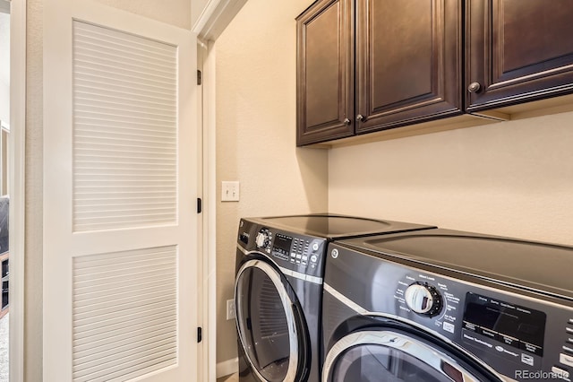 washroom with cabinet space and washing machine and clothes dryer