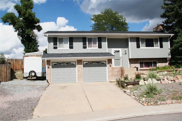 1008 Park View Ct, Castle Rock, CO 80104 - split foyer home featuring brick siding, driveway, fence, and a garage