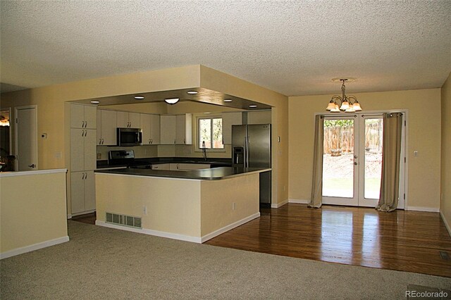 1008 Park View Ct, Castle Rock, CO 80104 - kitchen with stainless steel appliances, a chandelier, white cabinets, a textured ceiling, and dark colored carpet