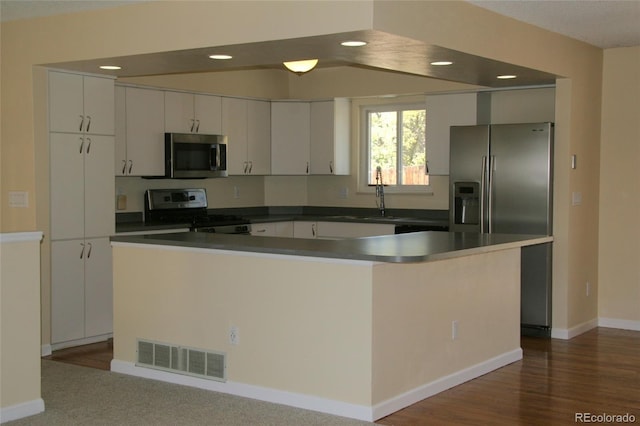 1008 Park View Ct, Castle Rock, CO 80104 - kitchen with appliances with stainless steel finishes, white cabinets, recessed lighting, dark countertops, and baseboards