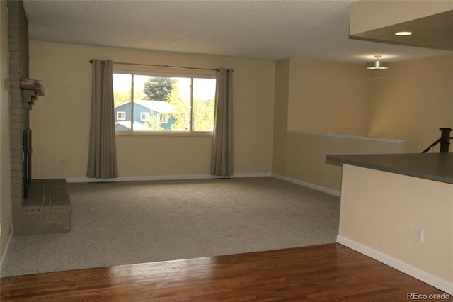 1008 Park View Ct, Castle Rock, CO 80104 - unfurnished living room featuring baseboards, a textured ceiling, a fireplace, wood finished floors, and carpet flooring