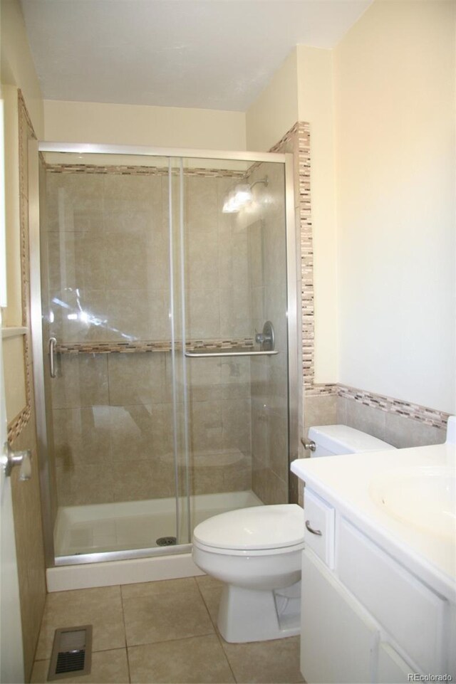 1008 Park View Ct, Castle Rock, CO 80104 - bathroom featuring tile patterned flooring, toilet, vanity, and a shower stall