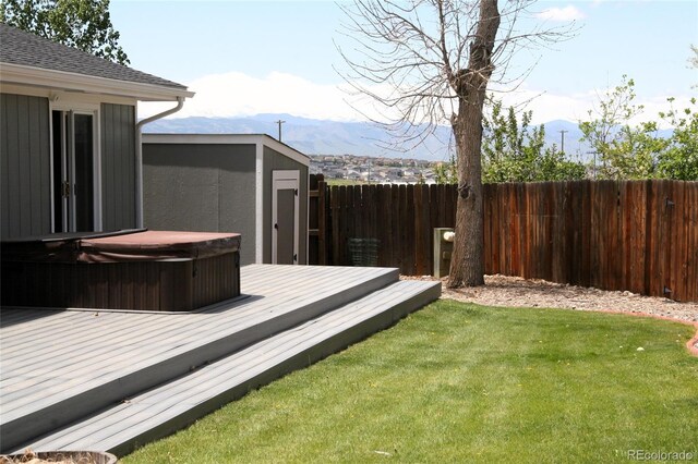 1008 Park View Ct, Castle Rock, CO 80104 - deck with a covered hot tub, a mountain view, a storage unit, and an outdoor structure