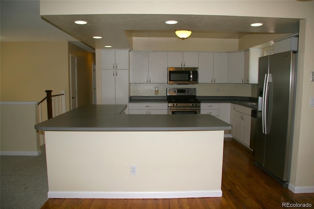 1008 Park View Ct, Castle Rock, CO 80104 - kitchen with appliances with stainless steel finishes, dark countertops, recessed lighting, and white cabinetry