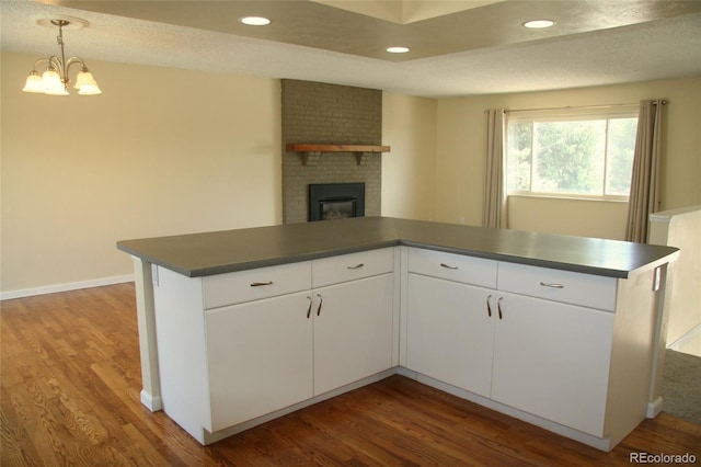 1008 Park View Ct, Castle Rock, CO 80104 - kitchen featuring dark countertops, wood finished floors, a brick fireplace, and recessed lighting