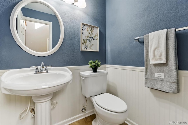 bathroom with hardwood / wood-style flooring and toilet