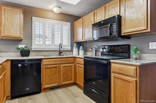 kitchen with sink, light wood-type flooring, and black appliances