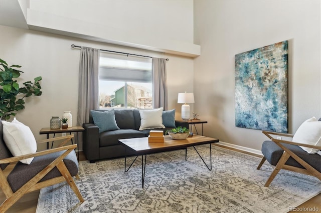 sitting room with a towering ceiling and hardwood / wood-style floors