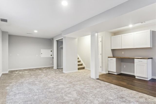 basement with dark carpet and built in desk