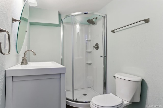 bathroom featuring vanity, toilet, and a shower with shower door