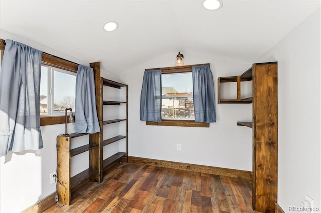 unfurnished bedroom featuring lofted ceiling and dark wood-type flooring