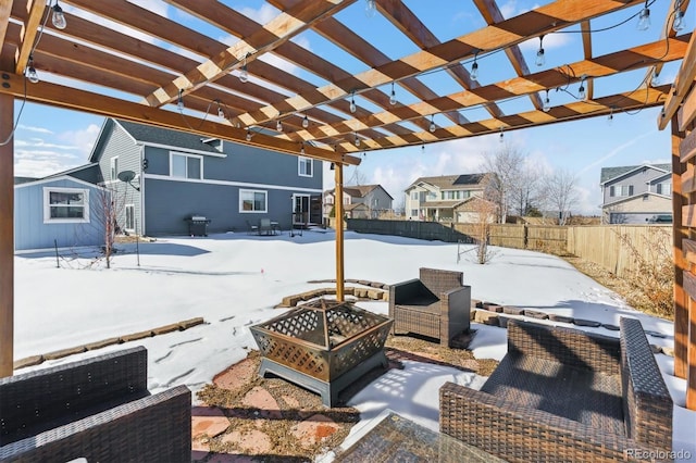 snow covered patio featuring an outdoor fire pit and a pergola