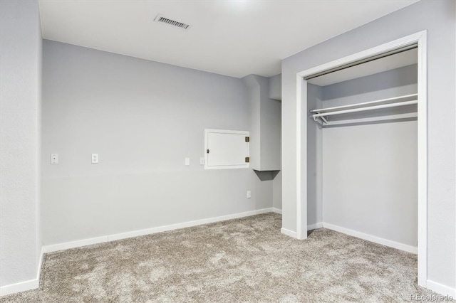 unfurnished bedroom featuring light colored carpet and a closet