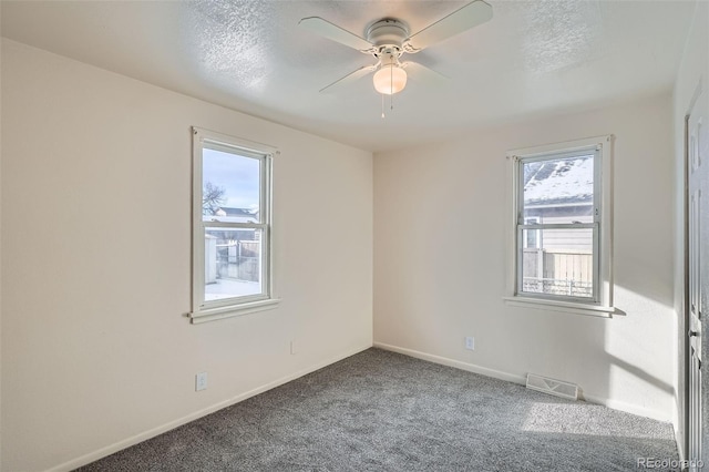 carpeted empty room with a textured ceiling and ceiling fan