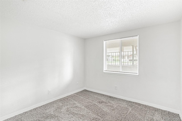 carpeted empty room with a textured ceiling