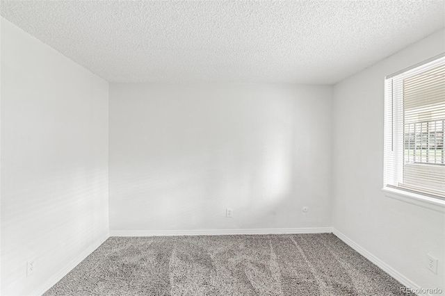 carpeted empty room with a textured ceiling