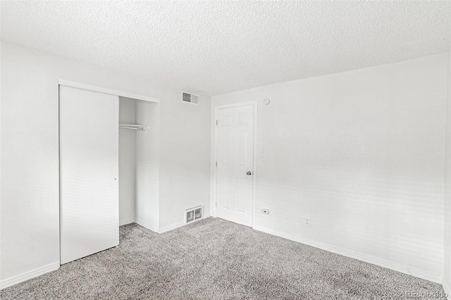 unfurnished bedroom featuring a closet, a textured ceiling, and carpet flooring