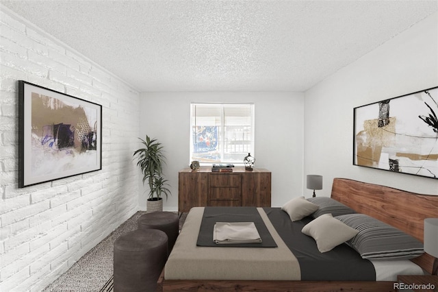 bedroom with a textured ceiling and brick wall