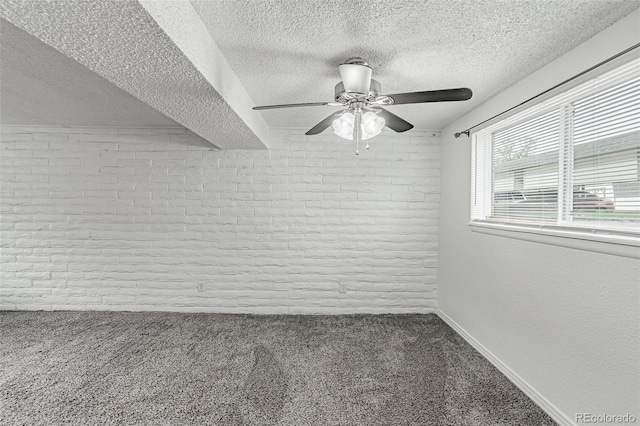 unfurnished room featuring carpet flooring, brick wall, and a textured ceiling