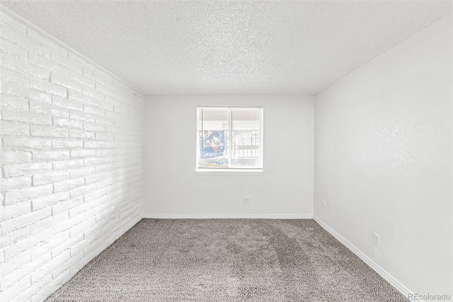 unfurnished room featuring brick wall, carpet, and a textured ceiling