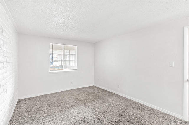 carpeted empty room featuring a textured ceiling