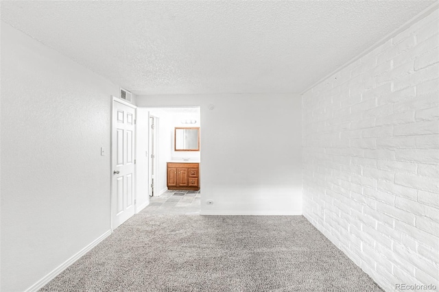 spare room with a textured ceiling and light colored carpet