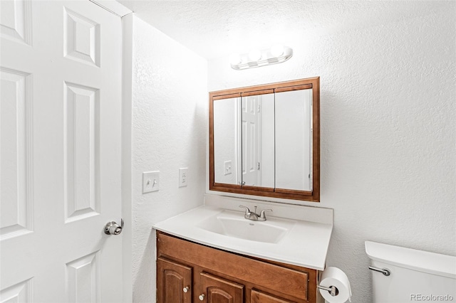 bathroom featuring vanity, toilet, and a textured ceiling