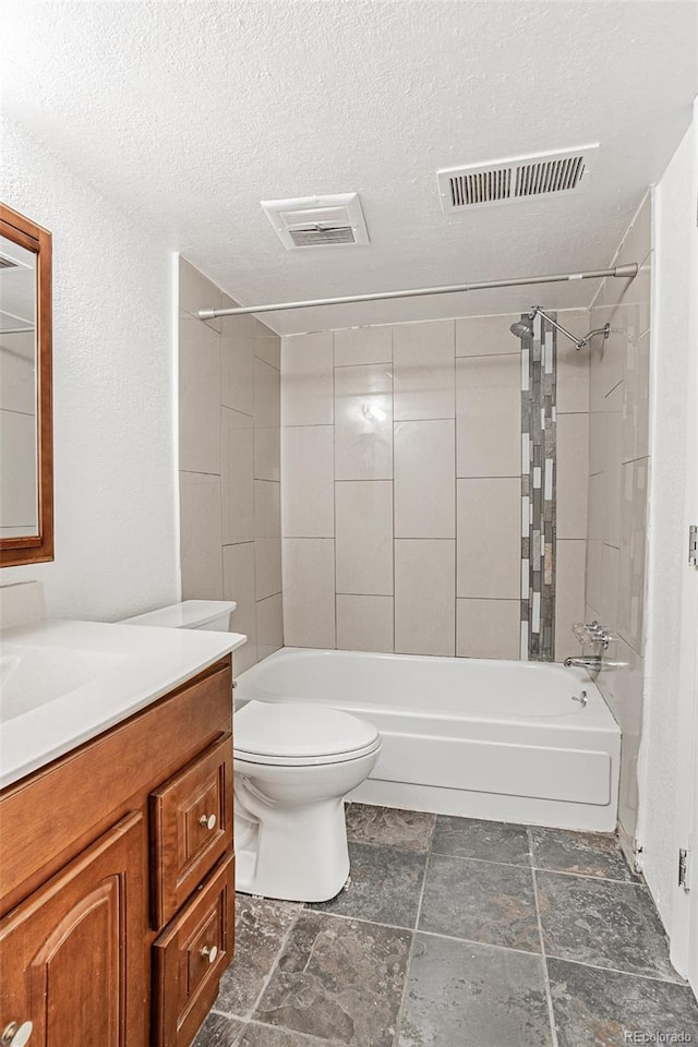 full bathroom featuring vanity, tiled shower / bath combo, a textured ceiling, and toilet