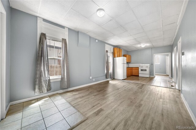 741 Mariposa St, Denver, CO 80204 - unfurnished living room featuring light wood-style flooring, a drop ceiling, and baseboards