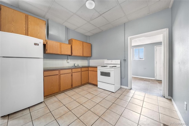 741 Mariposa St, Denver, CO 80204 - kitchen featuring white appliances, a sink, a paneled ceiling, light tile patterned flooring, and baseboards