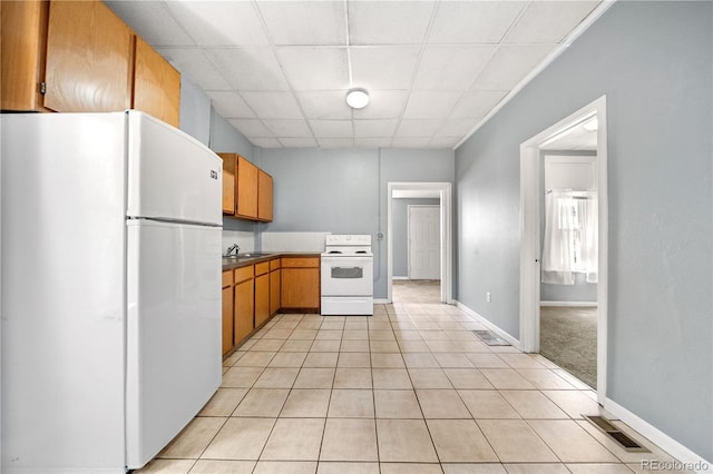 741 Mariposa St, Denver, CO 80204 - kitchen with white appliances, a paneled ceiling, light tile patterned flooring, a sink, and baseboards