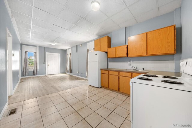741 Mariposa St, Denver, CO 80204 - kitchen featuring white appliances, a sink, light tile patterned floors, a drop ceiling, and baseboards